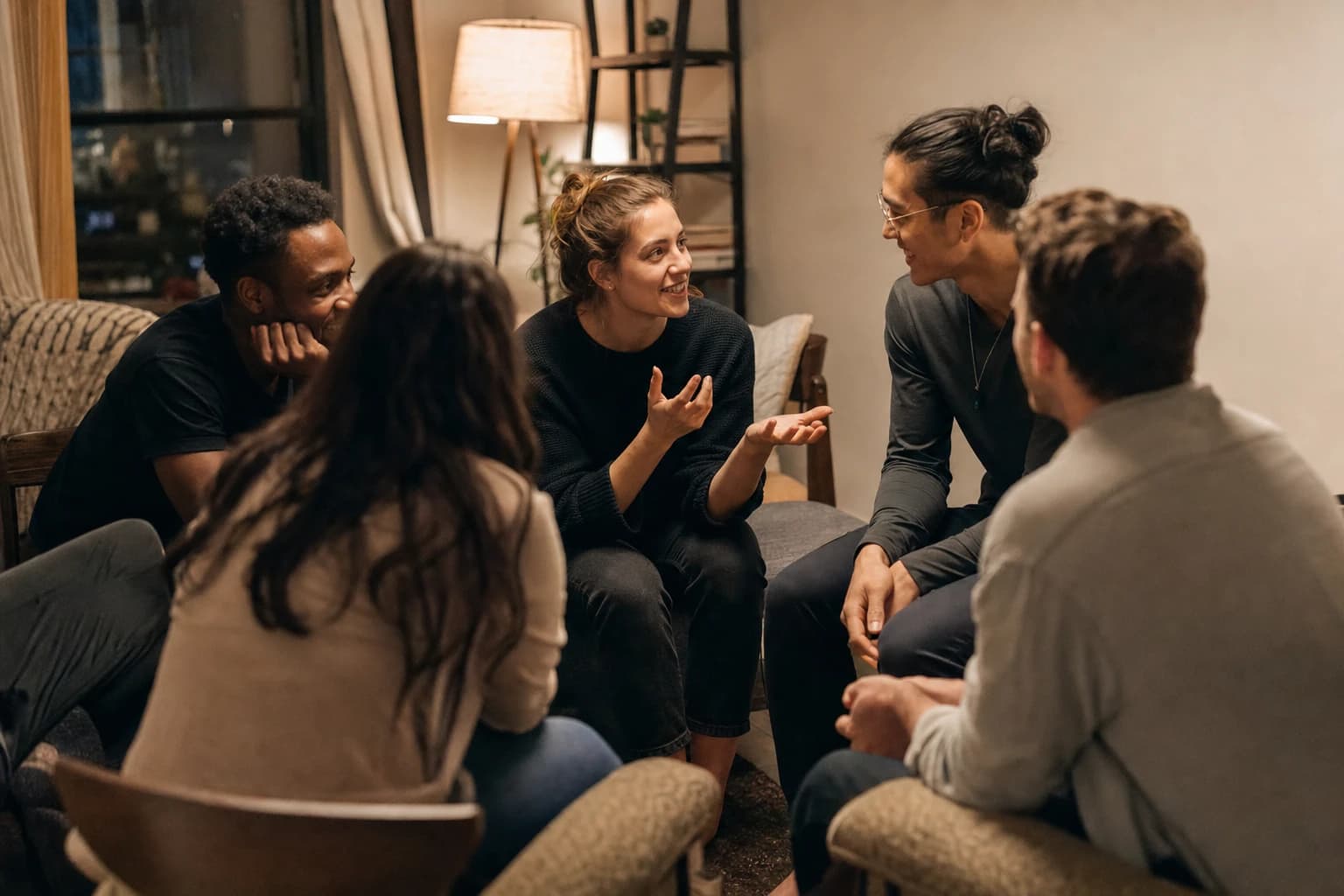 Adults sitting close together in a small apartment living room playing a conversation party game