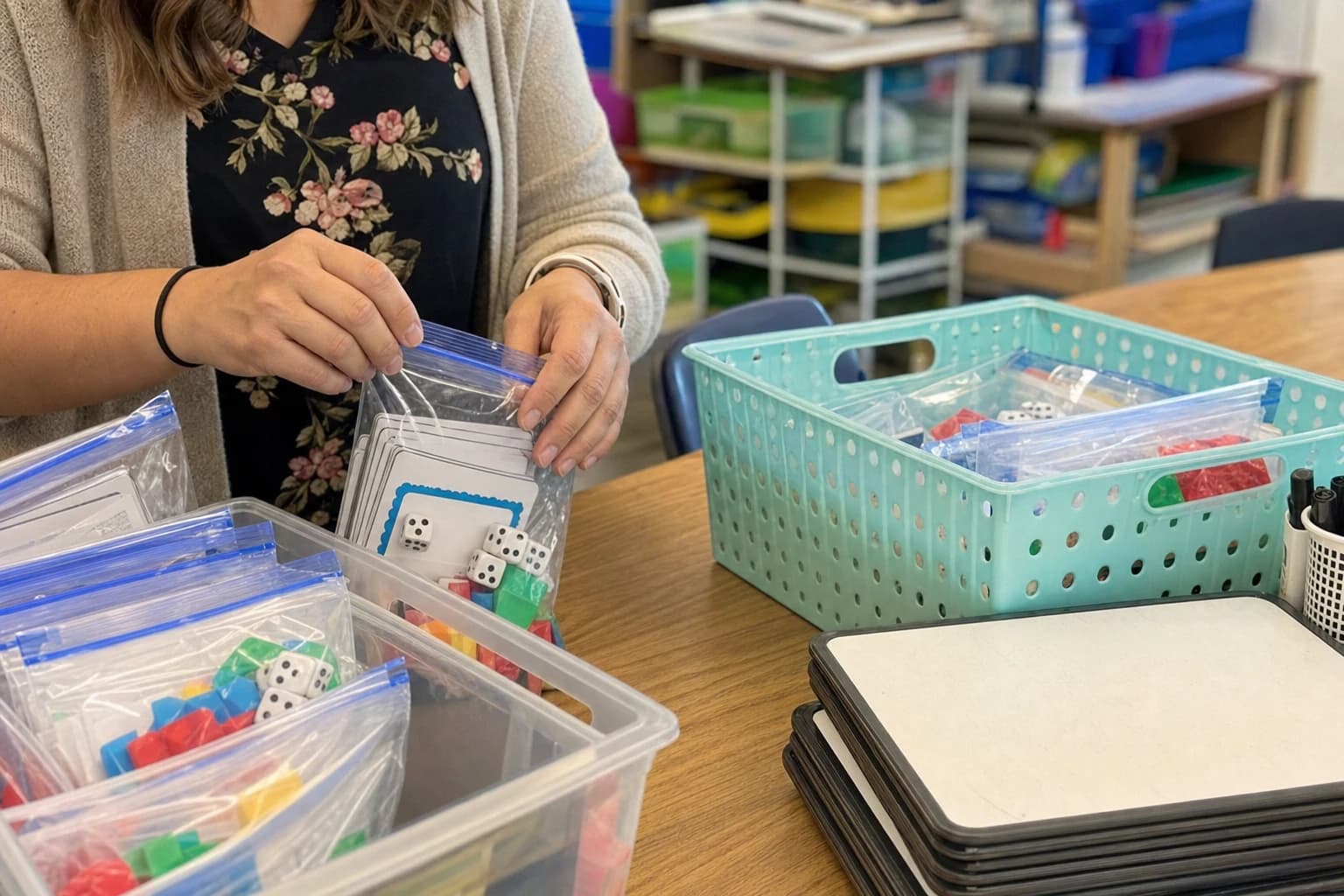Teacher organizing indoor recess supplies into labeled zipper pouches and clear plastic bins